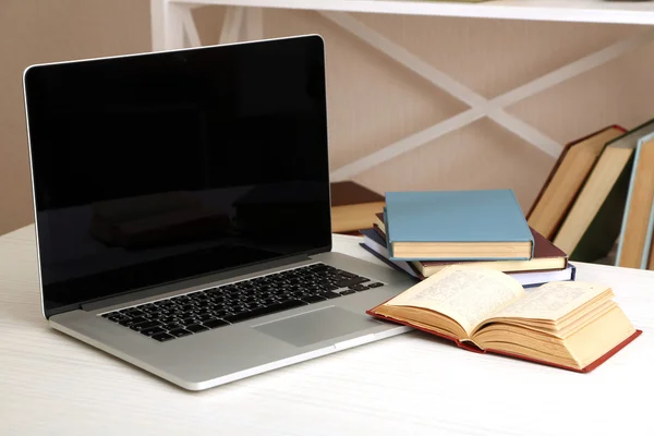 Ноутбук с книгами на столе в номере — стоковое фото