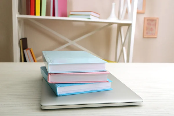 Stapel boeken met laptop op tafel close-up — Stockfoto