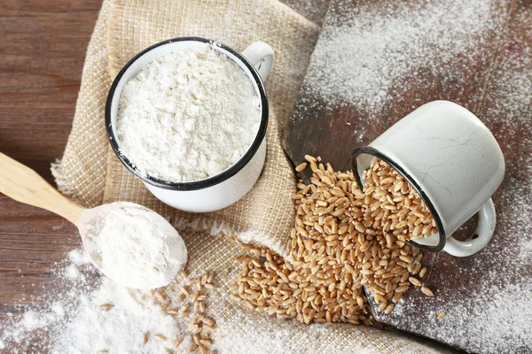 Whole flour with wheat on wooden table, closeup — Stock Photo, Image