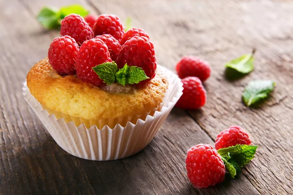 Läckra cupcake med bär och färsk mynta på träbord nära håll — Stockfoto