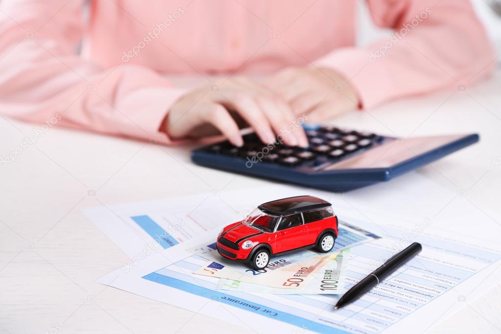 Toy car and documents on table. Car insurance concept