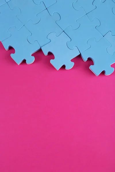 Puzzle pezzi su sfondo rosa — Foto Stock