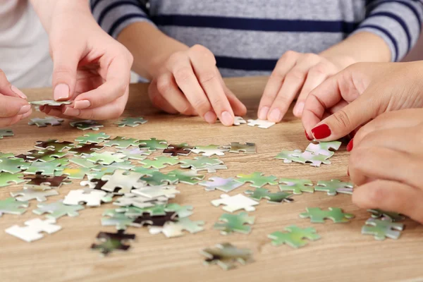 Weibliche Hände beim Zusammensetzen von Puzzle — Stockfoto