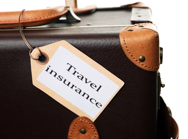 Чемодан с лейблом TRAVEL INSURANCE — стоковое фото