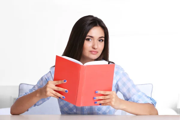 Girl reading book in room — Stok fotoğraf