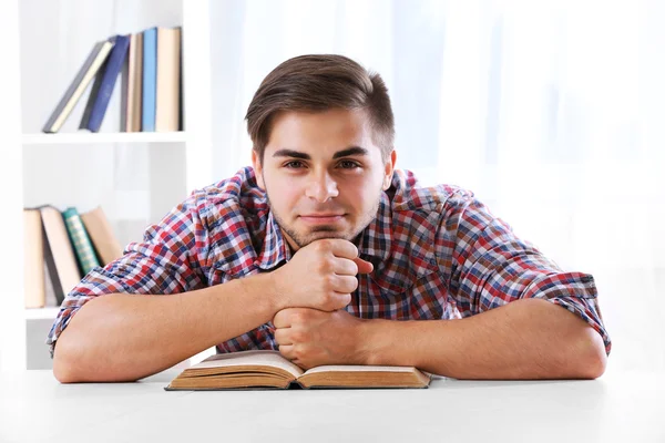 Man lezing boek aan tafel — Stockfoto