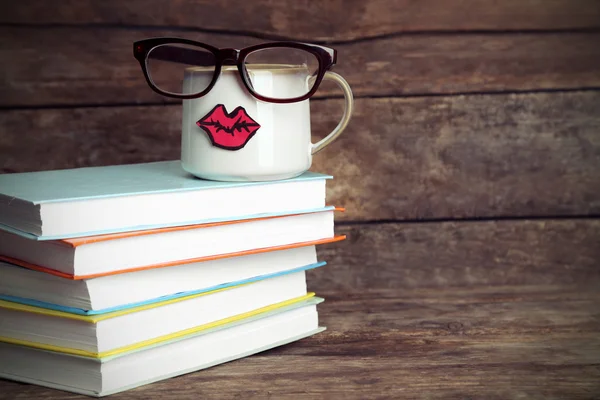 Boeken en cup met lippen — Stockfoto