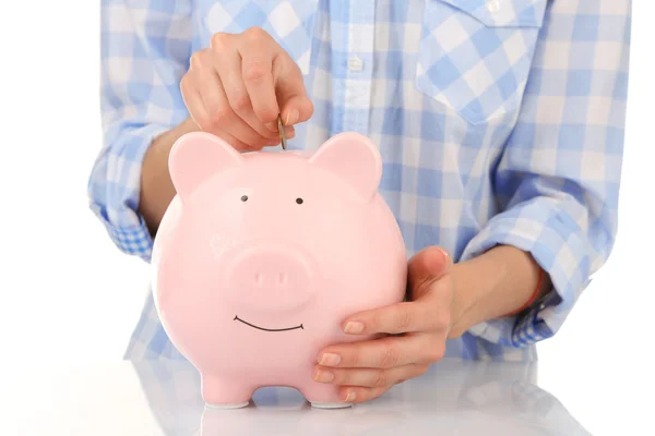 Hands putting coin into piggy bank — Stock Photo, Image