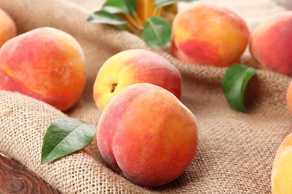 Fresh peaches on sackcloth — Stock Photo, Image