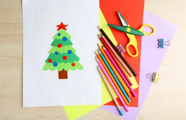 Creative paper Christmas tree on white paper sheet, scissors and colorful crayons on color table background — Stock Photo, Image