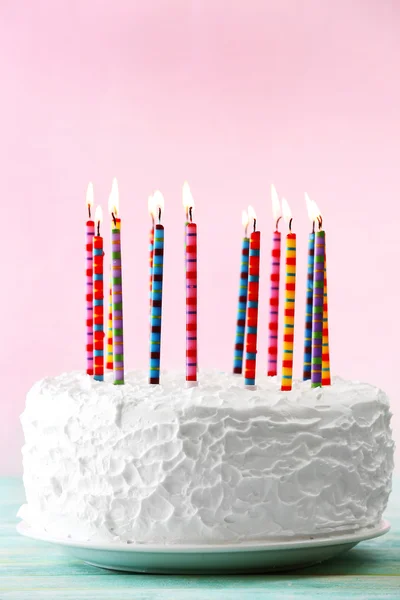 Gâteau d'anniversaire avec des bougies sur fond de couleur — Photo