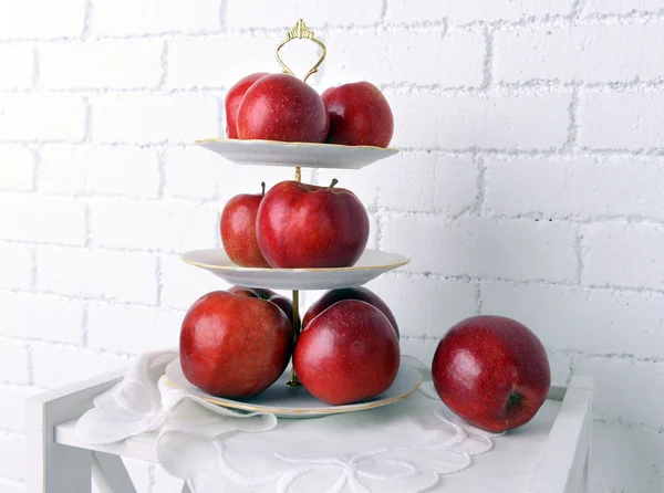 Leckere reife Äpfel auf Serviertablett auf Backsteinwand Hintergrund — Stockfoto