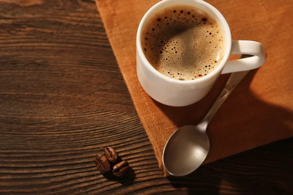 Xícara de café em guardanapo na mesa de perto — Fotografia de Stock