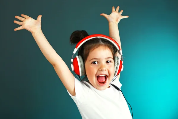 Hermosa niña escuchando música sobre fondo de color —  Fotos de Stock