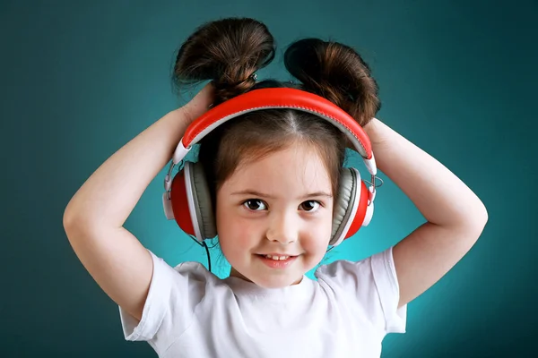 Renk arka plan üzerinde müzik dinlemek güzel küçük kız — Stok fotoğraf