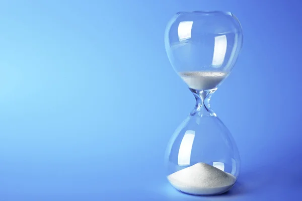 Hourglass on blue background — Stock Photo, Image