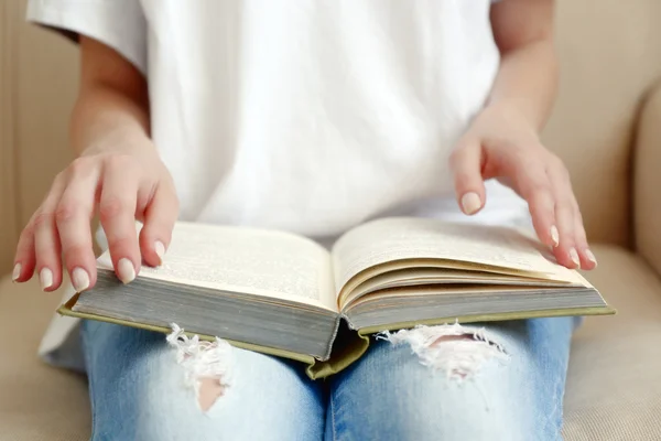 Woman reading book on sofa close up — Stock Photo, Image