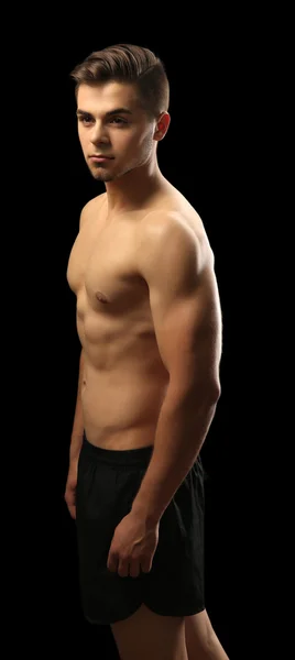 Muskel ung man på mörk bakgrund — Stockfoto