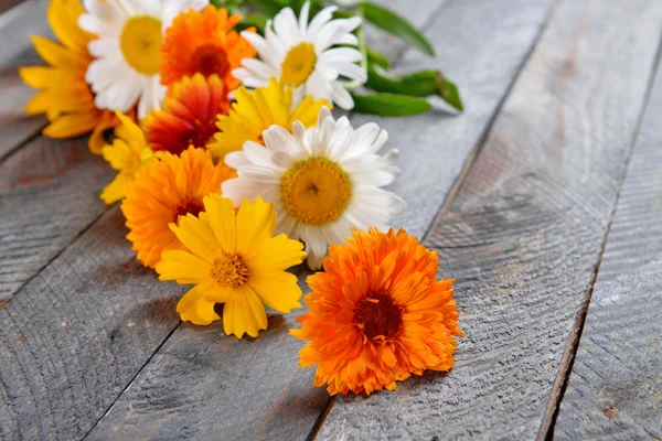 Heldere wilde bloemen op houten tafel, close-up — Stockfoto