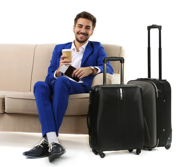 Business man with suitcase sitting on sofa isolated on white — Stock Photo, Image