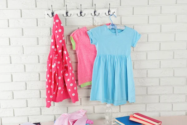 Children things hanging on wall and stacked in room — Stock Photo, Image