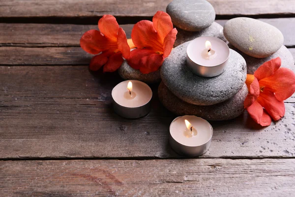 Schöne Wellness-Komposition mit Kerzen und Blumen auf Holztisch in Nahaufnahme — Stockfoto