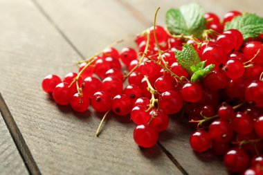 Ahşap arka plan üzerinde olgun kırmızı kuş üzümü