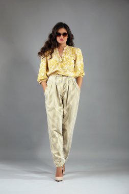 Gri arka plan üzerinde retro tarzı giyinmiş genç kadın