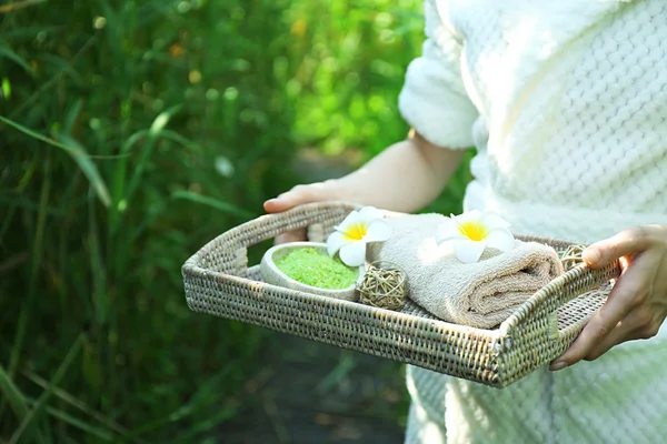 강에 녹색 갈에 스파 제품의 트레이 함께 여성 손 — 스톡 사진