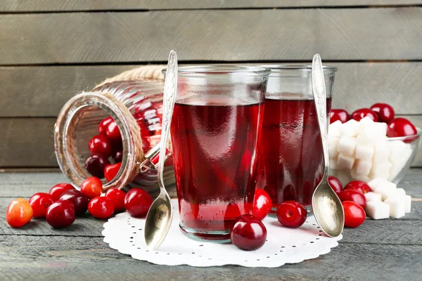 Glazen zoete zelfgemaakte kersen compote op tafel op houten achtergrond — Stockfoto