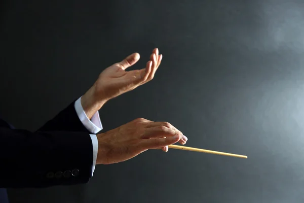 Music conductor hands with baton