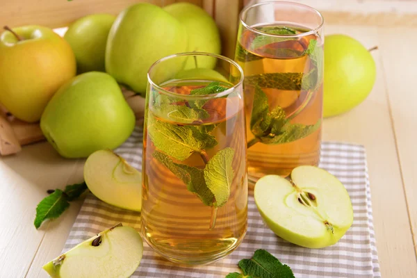Verres de jus de pomme aux fruits et menthe fraîche sur la table close up — Photo