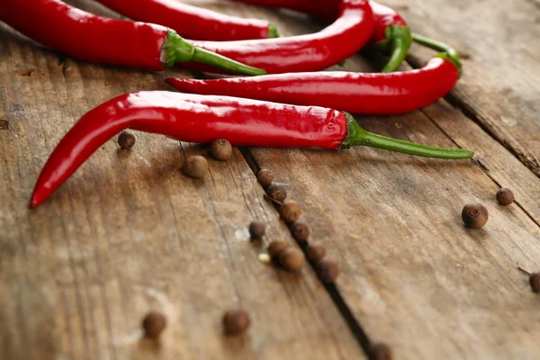 Pimientos rojos picantes con especias en la mesa de madera de cerca — Foto de Stock