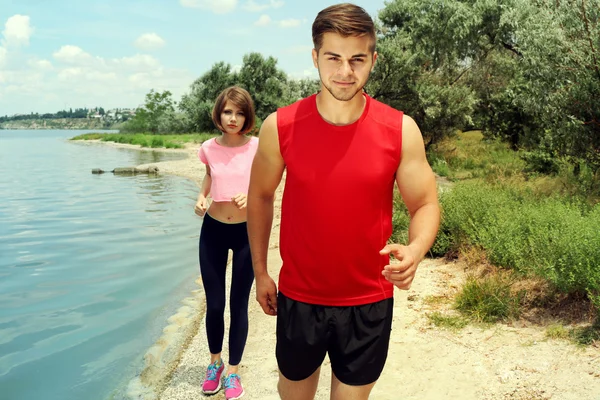 Jóvenes corriendo en la playa — Foto de Stock