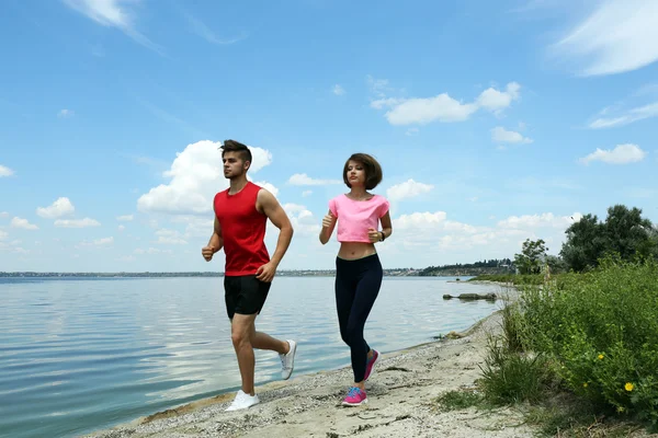 Jóvenes corriendo en la playa — Foto de Stock