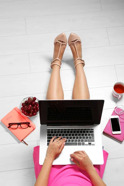 Vista dall'alto della giovane donna seduta al piano con computer portatile — Foto Stock