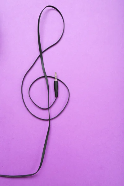 Clef de fones de ouvido cabo no fundo roxo — Fotografia de Stock