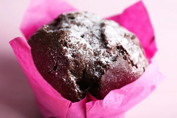 Choklad cupcake i rosa papper på träbord, närbild — Stockfoto