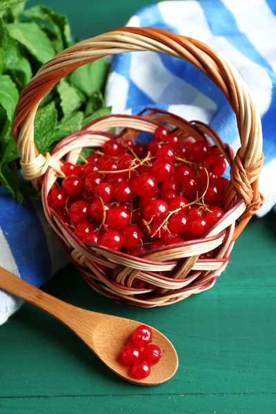 Groseille rouge mûre dans un panier en osier sur fond en bois — Photo