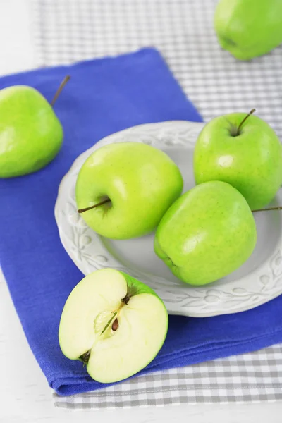 Groene appels in plaat op tafel met servet, close-up — Stockfoto