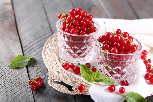 Groselhas vermelhas frescas em copos na mesa de perto — Fotografia de Stock