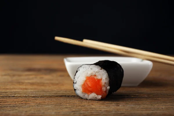 Roll with sauce and wooden sticks on dark background — Stock Photo, Image