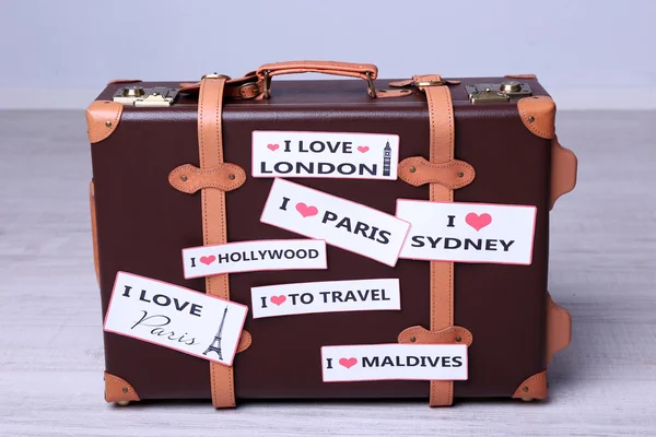 Suitcase with stickers on floor — Stock Photo, Image