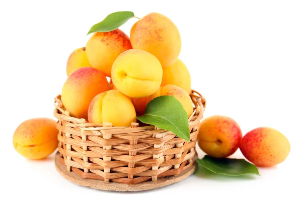 Abricots mûrs dans un bol en osier isolé sur blanc — Photo