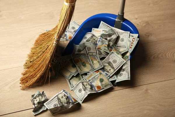 Broom sweeps dollars in garbage scoop — Stock Photo, Image