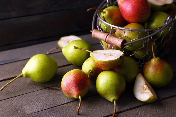 Rijp smakelijke peren in mand op tafel close-up — Stockfoto