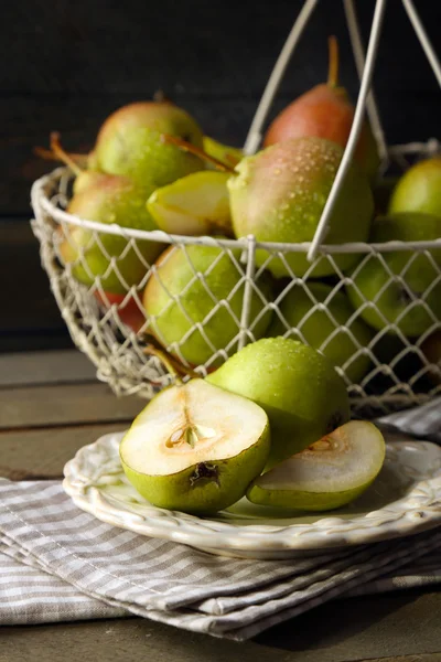 Rijp smakelijke peren in mand op tafel close-up — Stockfoto