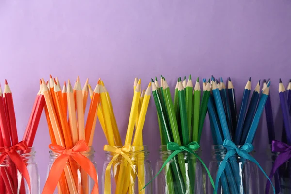 Bright pencils in glass jars — Stock Photo, Image