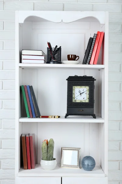 Books and decor on shelves — Stock Photo, Image