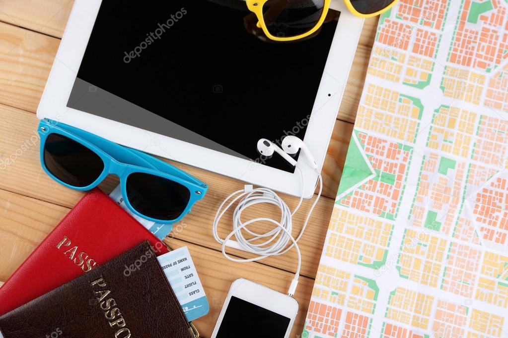 Sunglasses, passports, tickets, PC tablet, close up, on wooden background. Preparing for travel concept